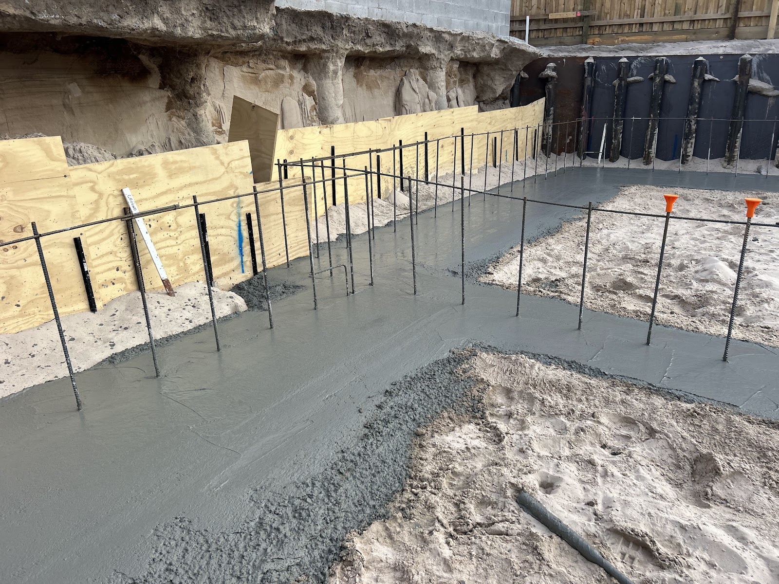 Slab being poured against formwork at the base of a rock-cut site