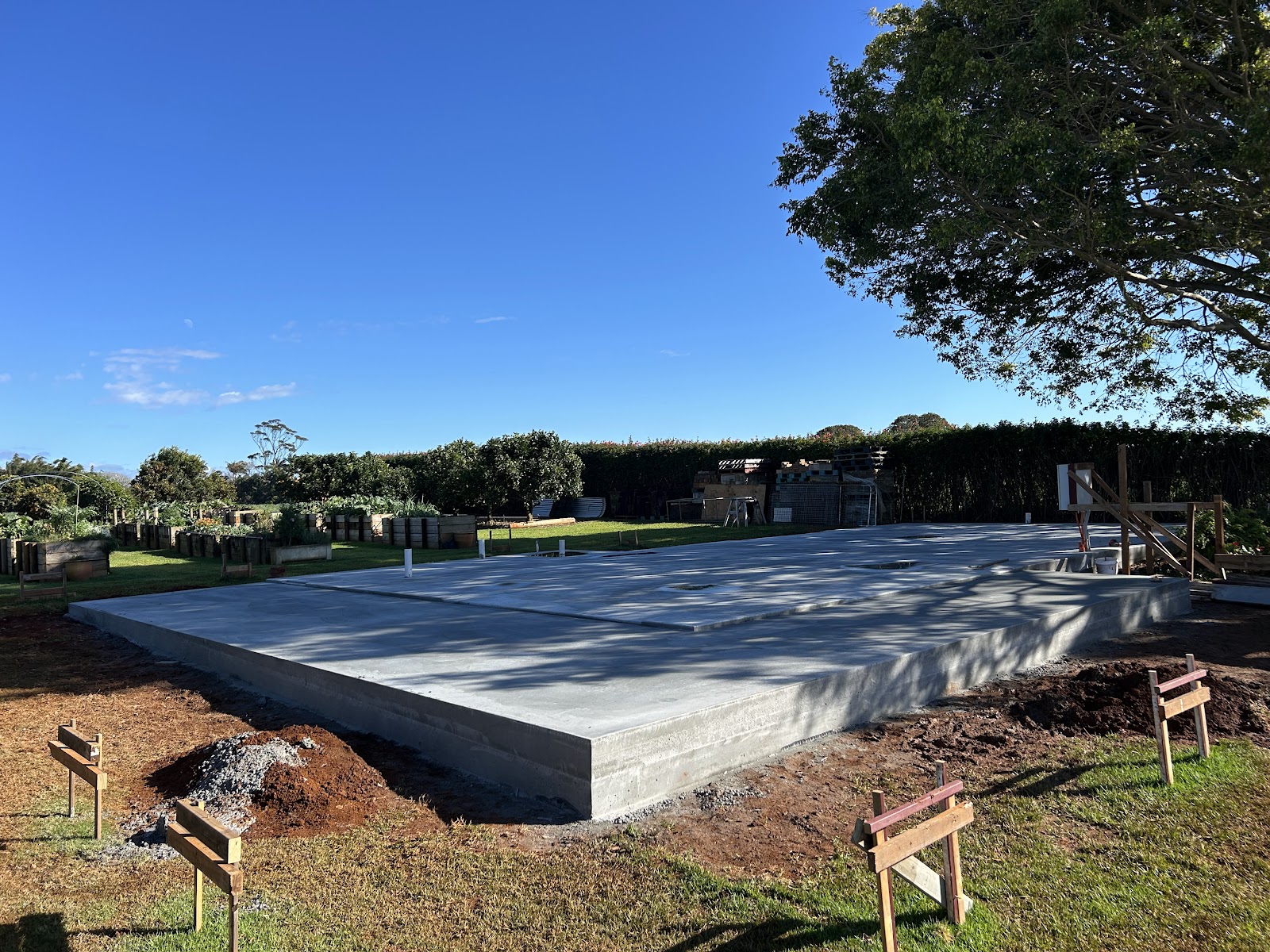 Finished concrete house slab on a green rural block under a blue sky